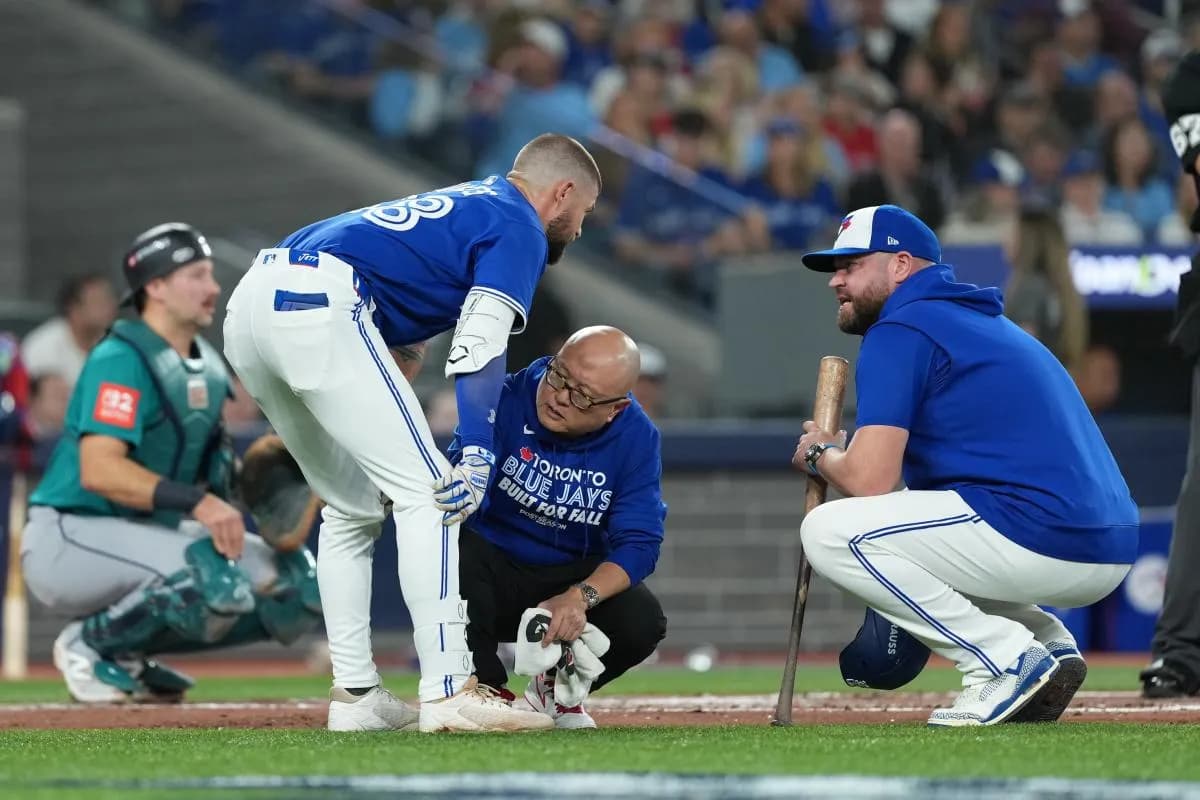 Toronto Blue Jays right fielder Nathan Lukes (38) is checked out by a trainer after hitting a foul ball off his knee in the first inning during game one of the ALCS round for the 2025 MLB playoffs against the Seattle Mariners at Rogers Centre.