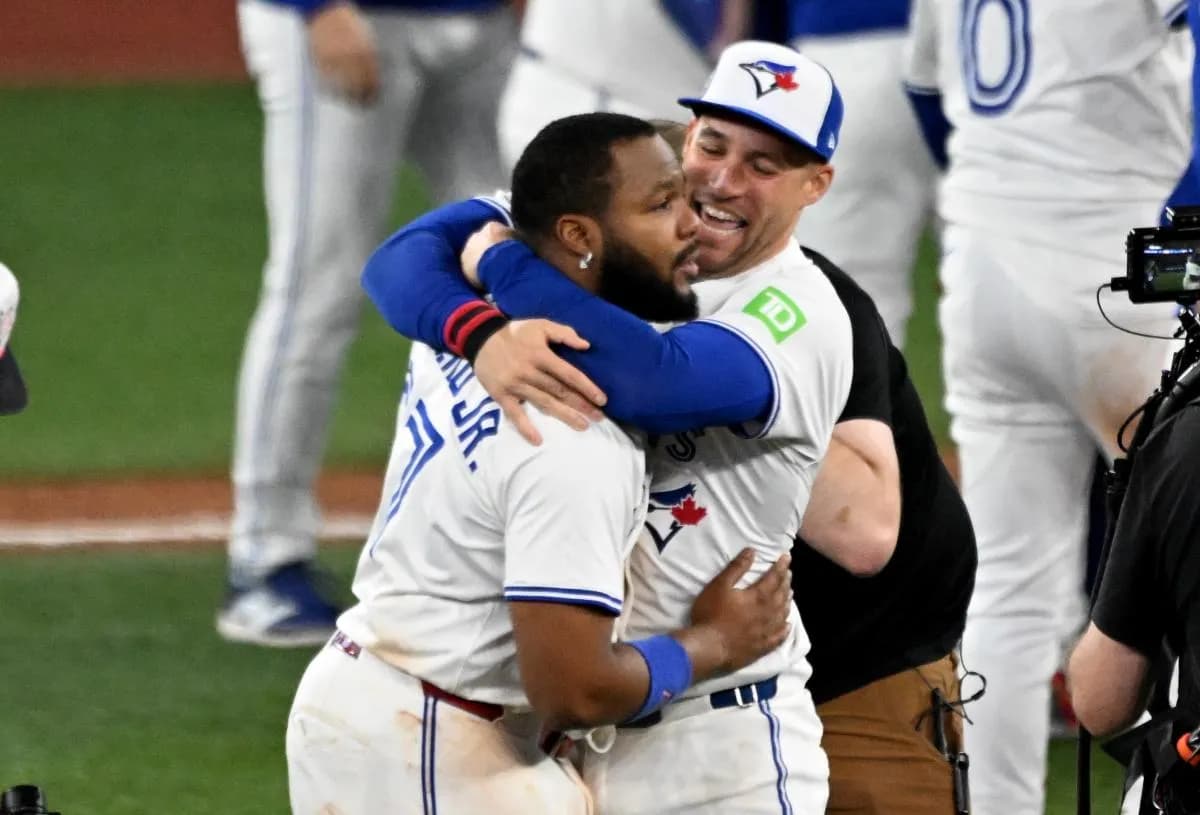 Toronto Blue Jays first baseman Vladimir Guerrero Jr. (27) and designated hitter George Springer (4) celebrate after winning game seven of the ALCS round for the 2025 MLB playoffs against the Seattle Mariners at Rogers Centre.