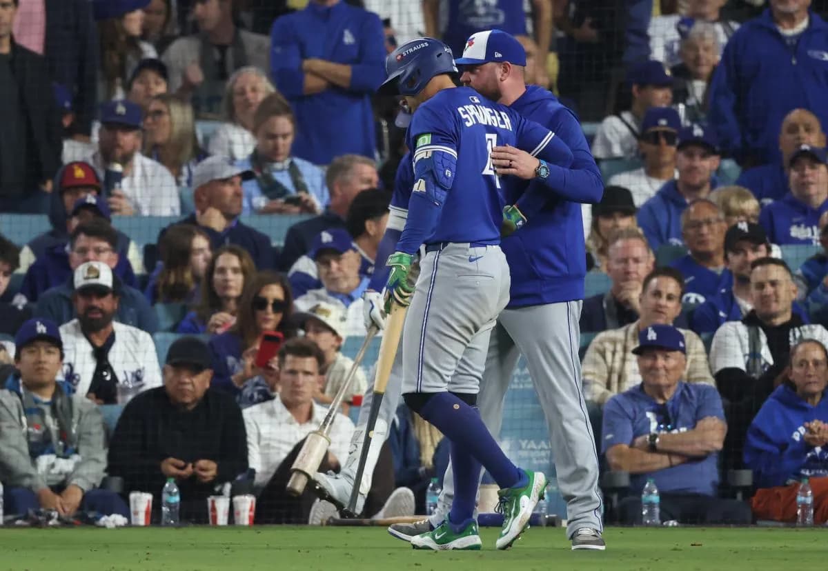 Toronto Blue Jays right fielder George Springer (4) talks to manager John Schneider (14) after an injury during the sixth inning against the Los Angeles Dodgers in game three of the 2025 MLB World Series at Dodger Stadium.