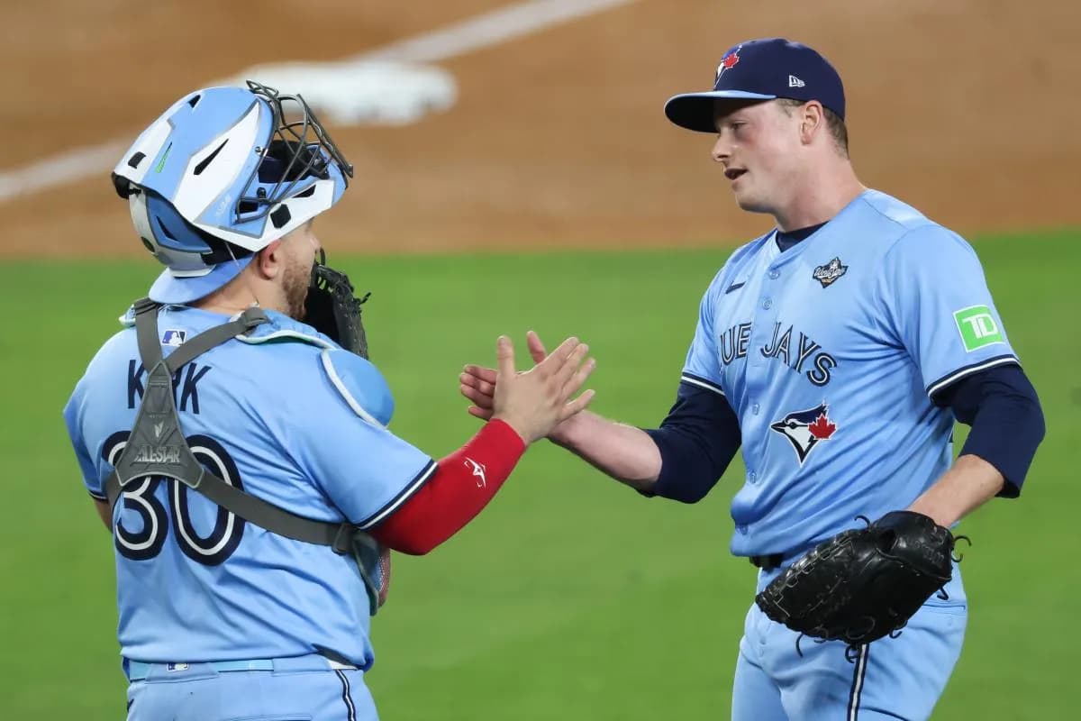 Toronto Blue Jays pitcher Louis Varland (77) celebrates with Toronto Blue Jays catcher Alejandro Kirk (30) after the game against the Los Angeles Dodgers during game four of the 2025 MLB World Series at Dodger Stadium.