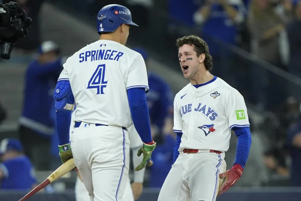 Toronto Blue Jays third baseman Ernie Clement (22) celebrates with right fielder George Springer (4) after scoring in the sixth inning during game seven of the 2025 MLB World Series at Rogers Centre.