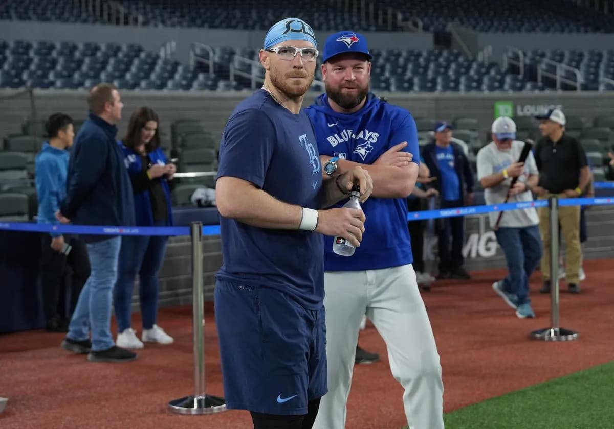 Tampa Bay Rays catcher Danny Jansen (19) talks with Toronto Blue Jays manager John Schneider (14) during batting practice before a game at Rogers Centre.