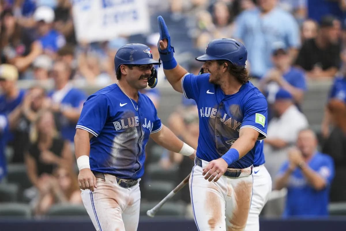 Toronto Blue Jays third base Addison Barger (47) and outfielder Davis Schneider (36) celebrate after scoring against the Tampa Bay Rays during the second inning at Rogers Centre.