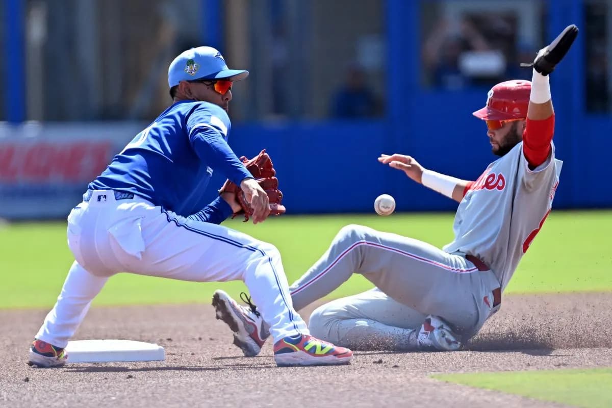 Philadelphia Phillies center fielder Justin Crawford (80) slides into second base as Toronto Blue Jays shortstop Andres Gimenez (0) waits for the ball during spring training at TD Ballpark.