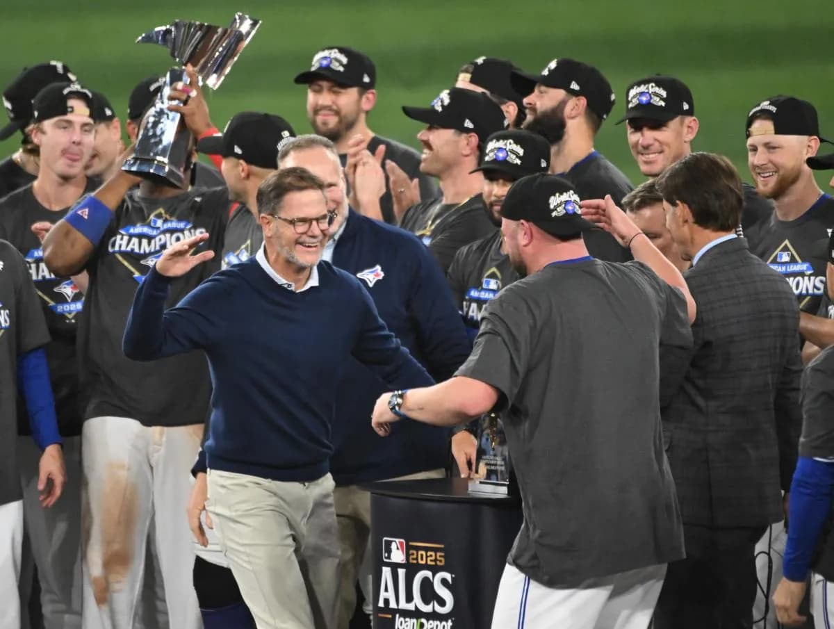 Toronto Blue Jays general manager Ross Atkins celebrates with manager John Schneider (14) after winning game seven of the ALCS round for the 2025 MLB playoffs against the Seattle Mariners at Rogers Centre.