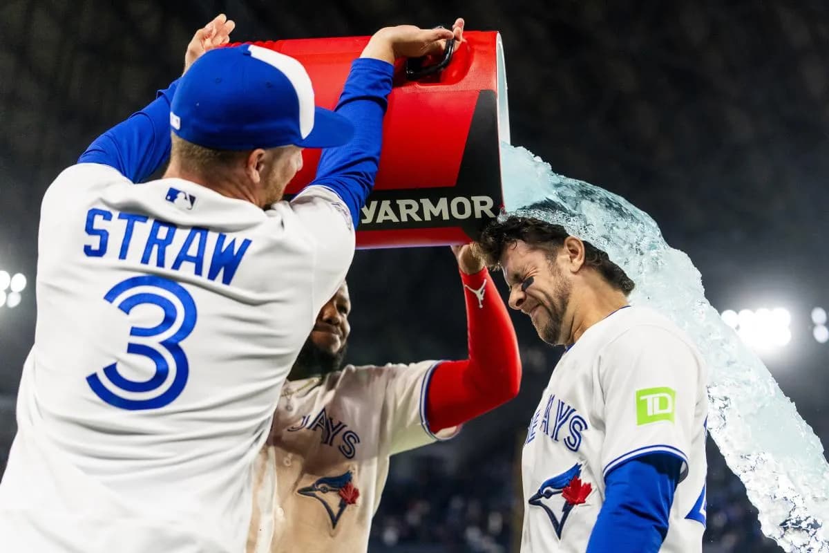 Toronto Blue Jays first baseman Vladimir Guerrero Jr. (27) and center fielder Myles Straw (3) pour a sports drink on third baseman Ernie Clement (22) after defeating the Athletics at Rogers Centre.