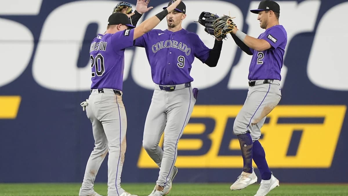 Colorado Rockies left fielder Troy Johnston (20) and center fielder Brenton Doyle (9) and right fielder Tyler Freeman (2) celebrate a win over the Toronto Blue Jays after the tenth inning at Rogers Centre.