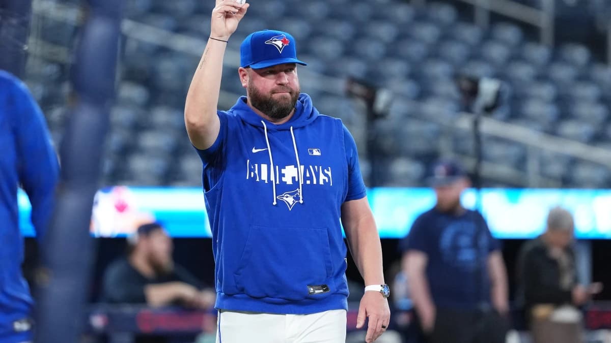 Toronto Blue Jays manager John Schneider (14) walks onto the field during batting practice before a game against the Cleveland Guardians at Rogers Centre.