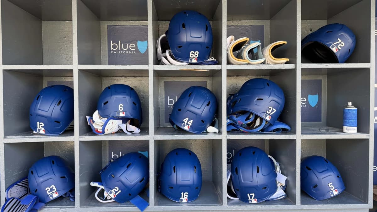The batting helmets of Los Angeles Dodgers catcher Dalton Rushing (68), shortstop Miguel Rojas (72), left fielder Alex Call (12), shortstop Hyeseong Kim (6), center fielder Andy Pages (44), left fielder Teoscar Hernandez (37), right fielder Kyle Tucker (23), third baseman Santiago Espinal (21), catcher Will Smith (16), left fielder Alex Call (12), first baseman Freddie Freeman (5) in the dugout at Dodger Stadium.