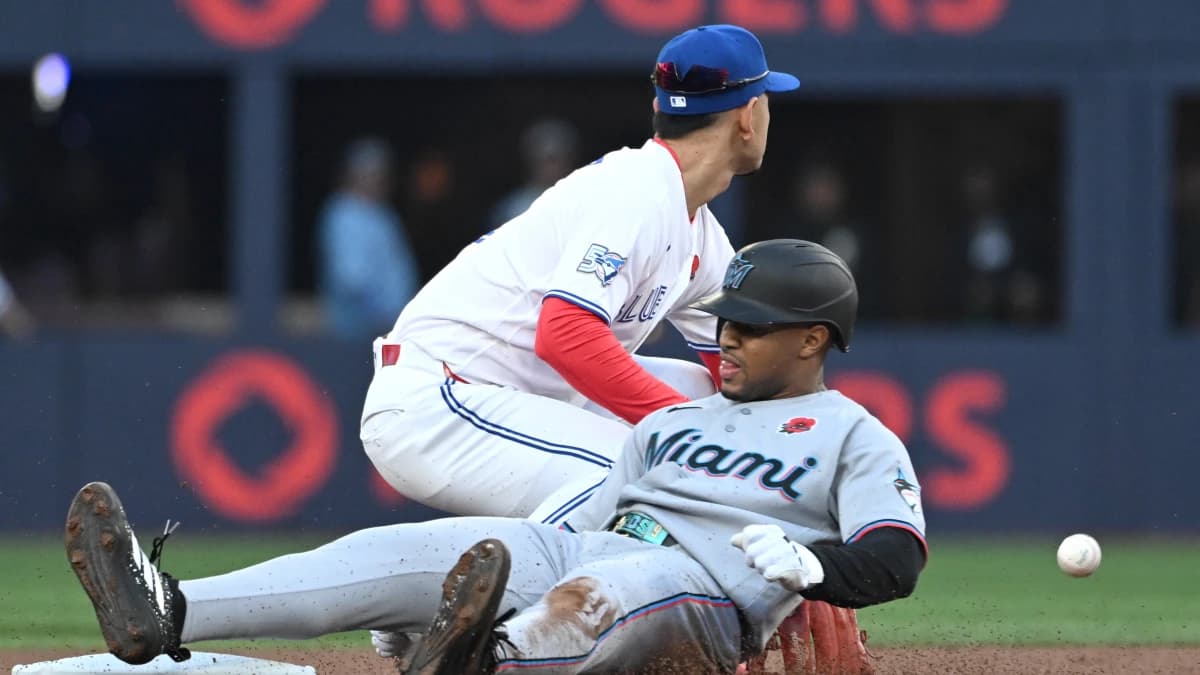 Miami Marlins second baseman Xavier Edwards (9) slides safely into second base after hitting a double as Toronto Blue Jays second baseman Andres Gimenez (0) takes the throw from the outfield in the first inning at Rogers Centre.
