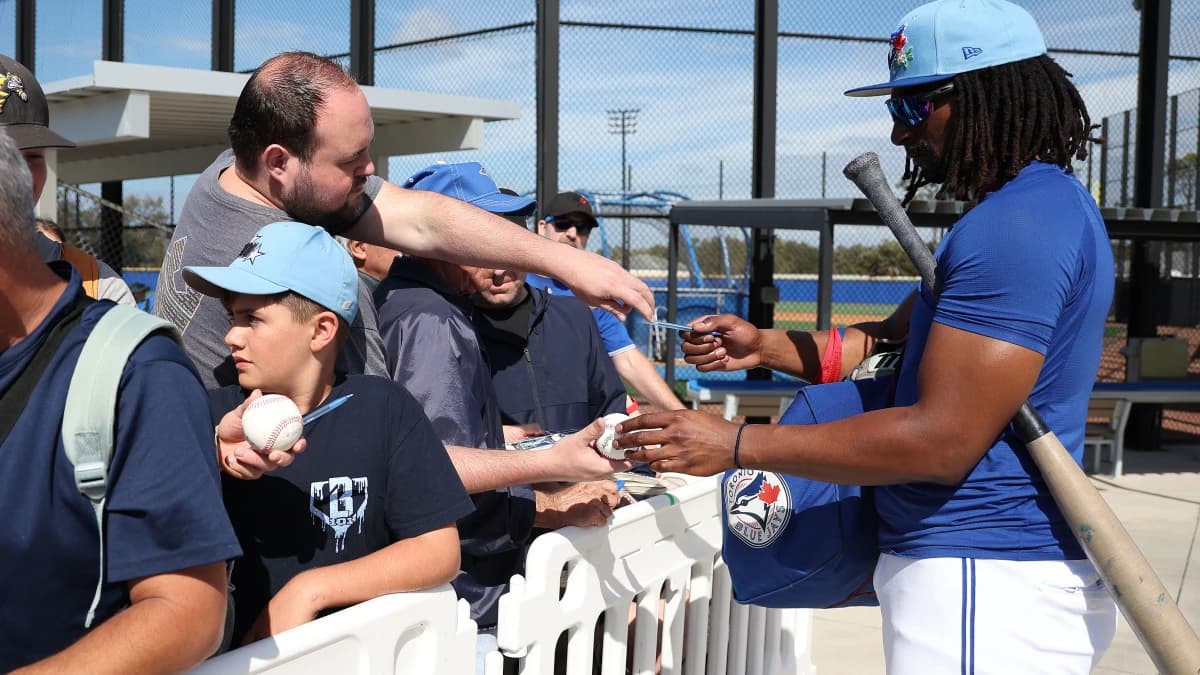 Toronto Blue Jays infielder Charles McAdoo (26) signs autographs during spring training practices.