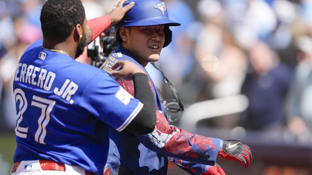 Toronto Blue Jays first baseman Vladimir Guerrero Jr. (27) puts the home run jacket onto Toronto Blue Jays third baseman Kazuma Okamoto (7) after his solo home run against the Miami Marlins during the sixth inning at Rogers Centre.