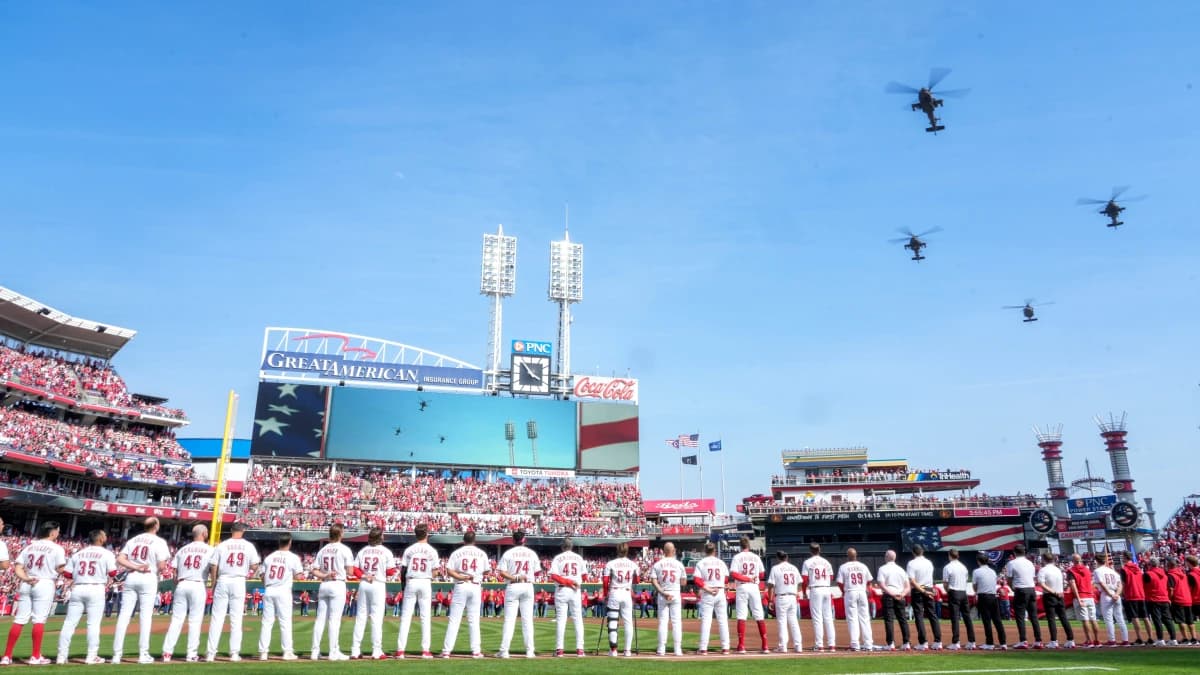 Three AH-64 Apache helicopters and one UH-60 Blackhawk helicopter from 1st Battalion, 101st Aviation Regiment, out of Fort Campbell, Kentucky, fly over during the National Anthem before the first inning of the MLB Opening Day game between the Cincinnati Reds and the Boston Red Sox at Great American Ball Park in downtown Cincinnati on Thursday, March 26, 2026. The game was tied at 0 after four innings.