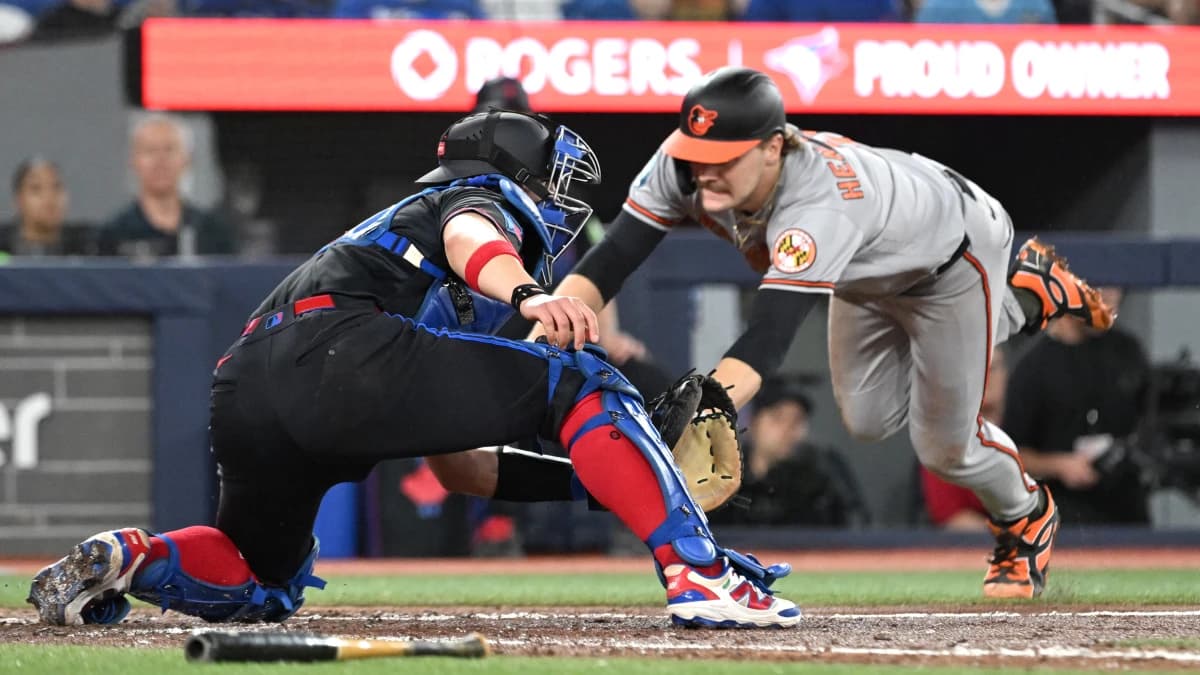 Baltimore Orioles shortstop Gunnar Henderson (2) dives into home plate to score a run ahead of the tag from Toronto Blue Jays catcher Brandon Valenzuela (59) in the sixth inning at Rogers Centre.