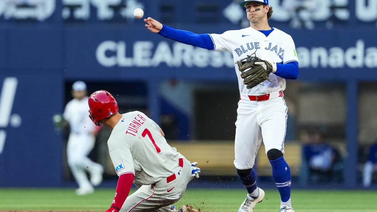 Toronto Blue Jays second baseman Ernie Clement (22) throws to first base against Philadelphia Phillies shortstop Trea Turner (7) during the third inning at Rogers Centre.