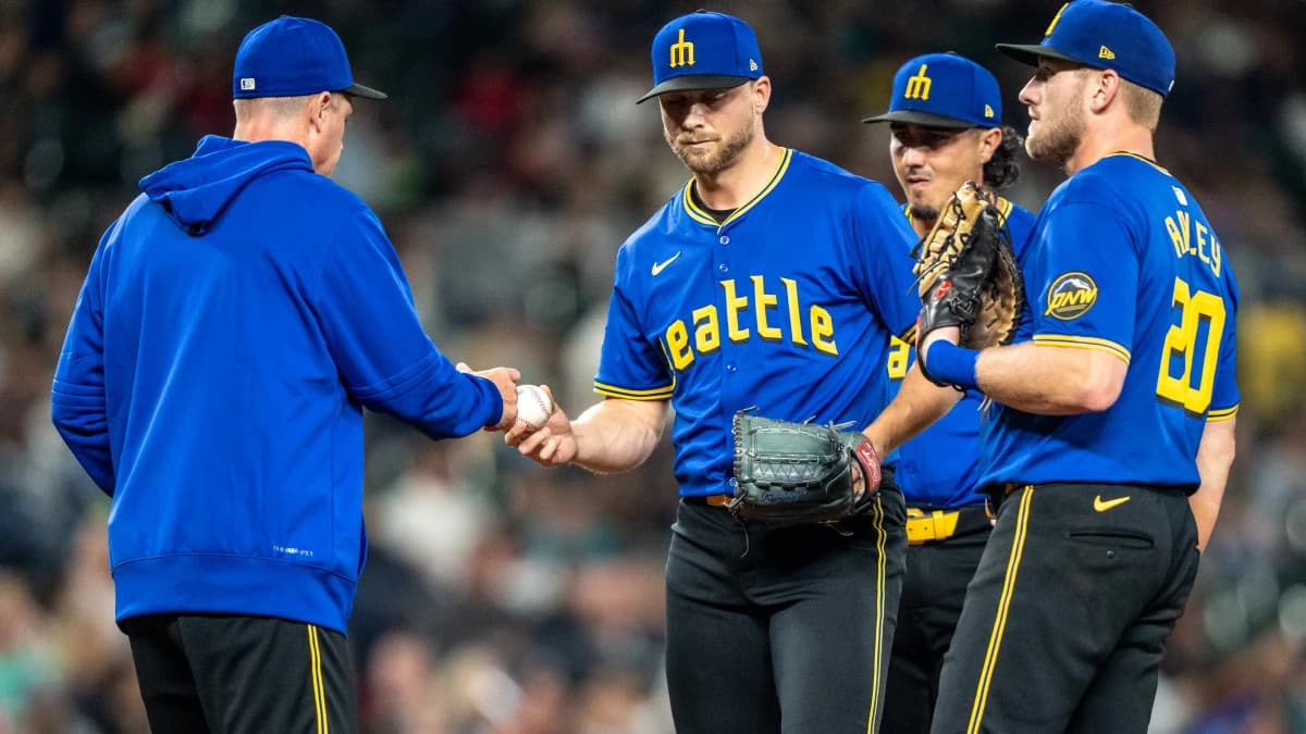 Seattle Mariners relief pitcher Austin Voth (30), second from left, is pulled by manager Dan Wilson, left, during a meeting at the mound with third baseman Josh Rojas (4), second from right, and first baseman Luke Raley (20) in the seventh inning against the Texas Rangers at T-Mobile Park.