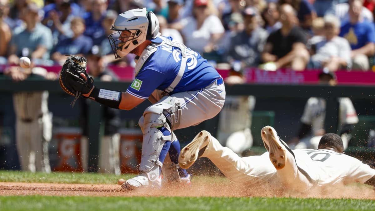 Seattle Mariners center fielder Victor Robles (10) slides home to score a run before Toronto Blue Jays catcher Alejandro Kirk (30) can receive the ball during the third inning at T-Mobile Park