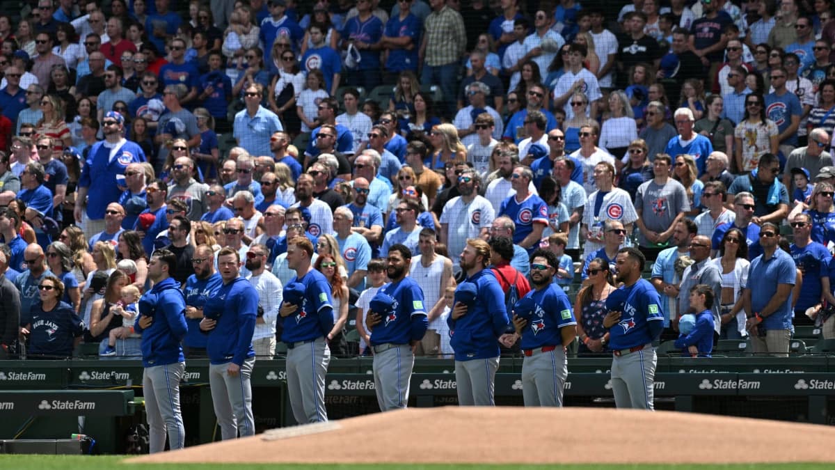 The Toronto Blue Jays stand during the Canadian national anthem prior to a game against the Chicago Cubs at Wrigley Field.