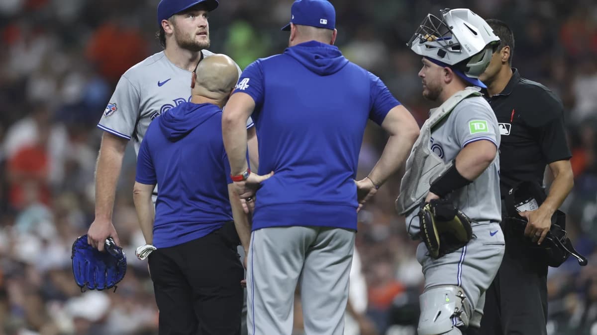 Toronto Blue Jays starting pitcher Trey Yesavage (39) is evaluated by a trainer after an apparent injury during the third inning against the Houston Astros at Daikin Park.
