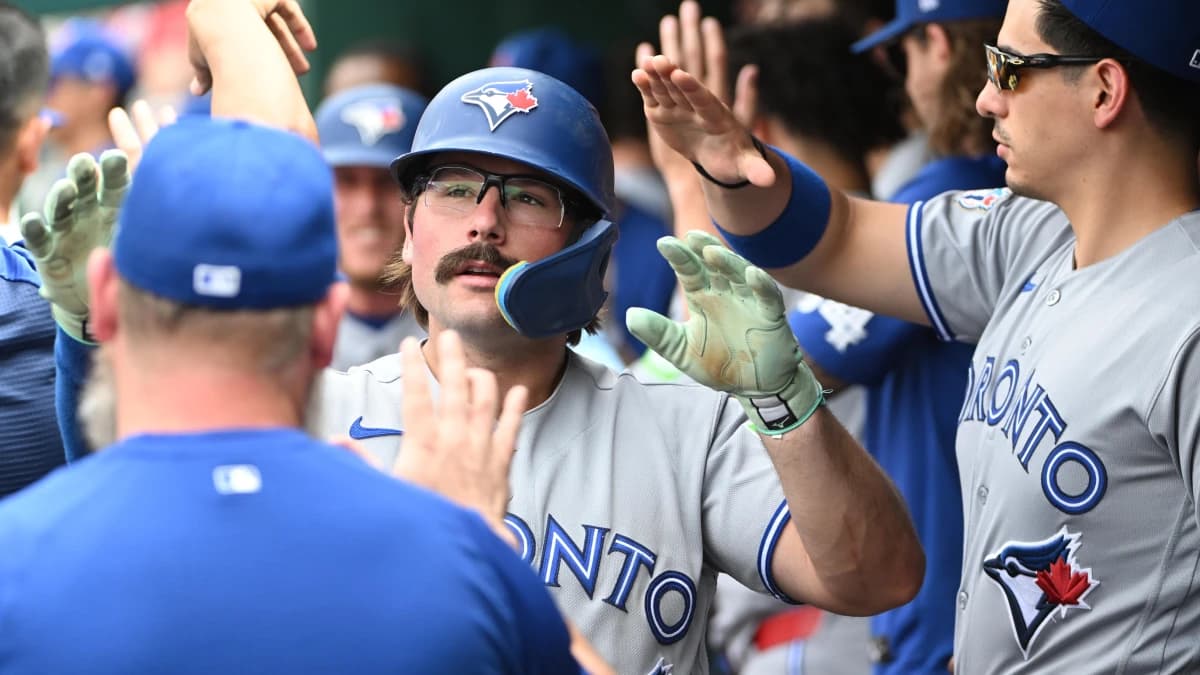 Toronto Blue Jays second baseman Davis Schneider (36) is congratulated by teammates after scoring a run against the Washington Nationals during the eighth inning at Nationals Park.