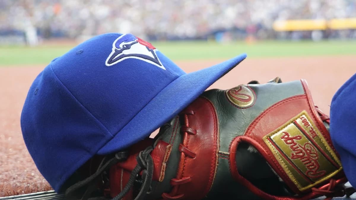 A Toronto Blue Jays hat and glove outside of the dugout during a game against the Texas Rangers at Rogers Centre