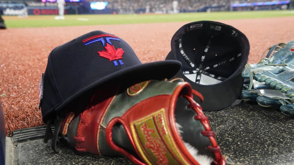 A Toronto Blue Jays hat and glove near the dugout during a game against the Detroit Tigers at Rogers Centre.