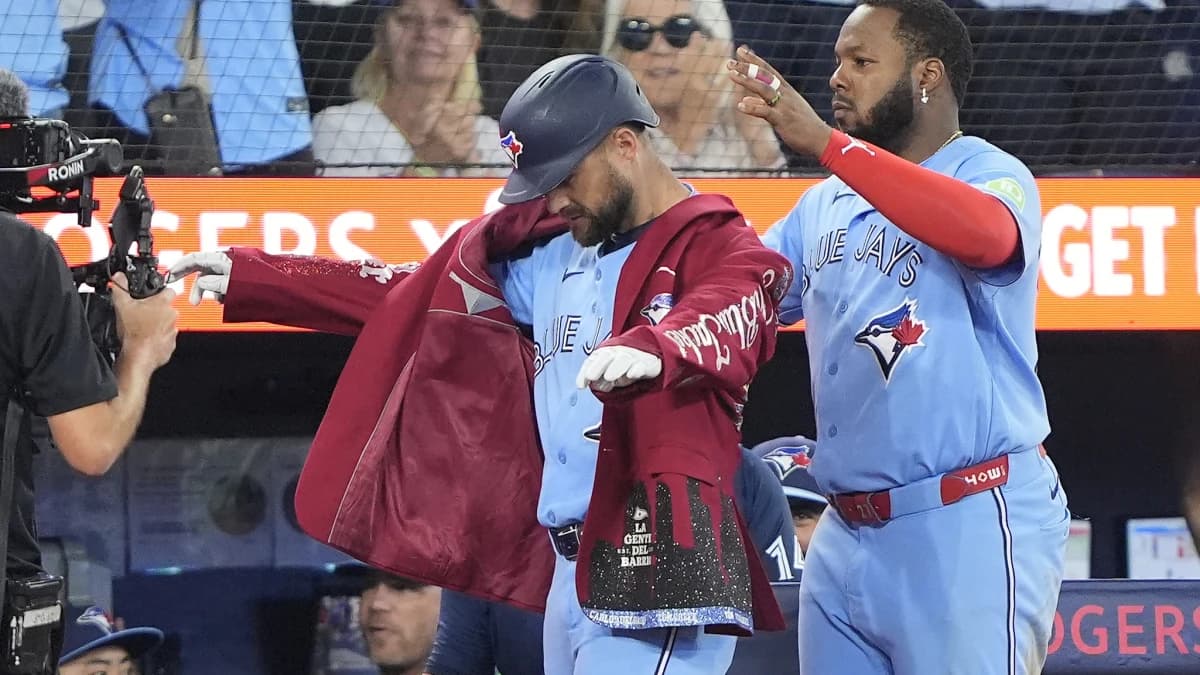 Toronto Blue Jays first baseman Vladimir Guerrero Jr. (27) puts the home run jacket onto right fielder Nathan Lukes (38) after his three run home run against the Kansas City Royals during the fourth inning at Rogers Centre.