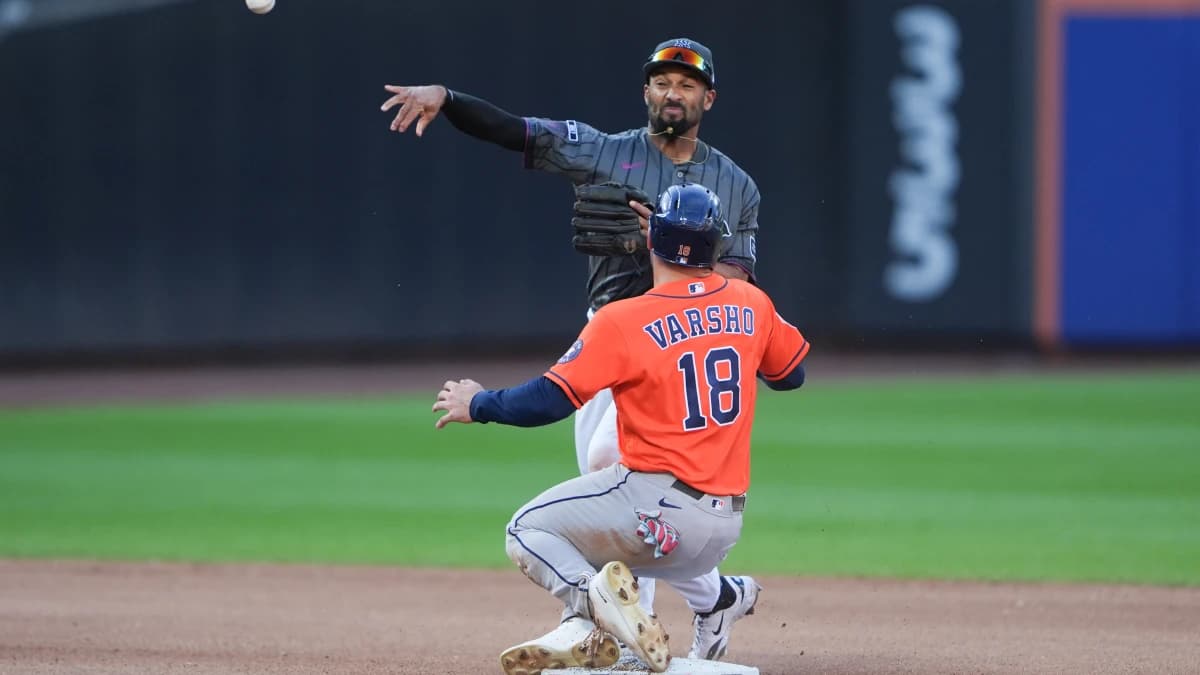 New York Mets second baseman Marcus Semien (10) attempts to turn a double play with Houston Astros center fielder Daulton Varsho (18) sliding into second base during the seventh inning at Citi Field.