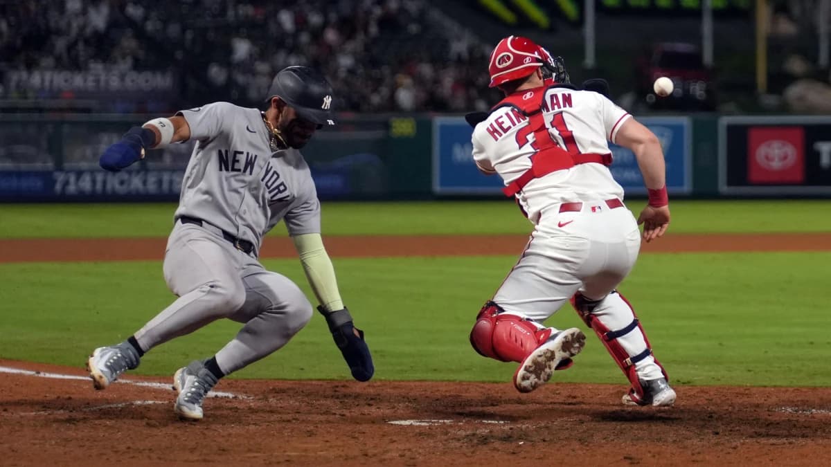 New York Yankees shortstop Jose Caballero (72) slides into home plate to beat a throw to Los Angeles Angels catcher Tyler Heineman (31) to score in the 10th inning at Angel Stadium