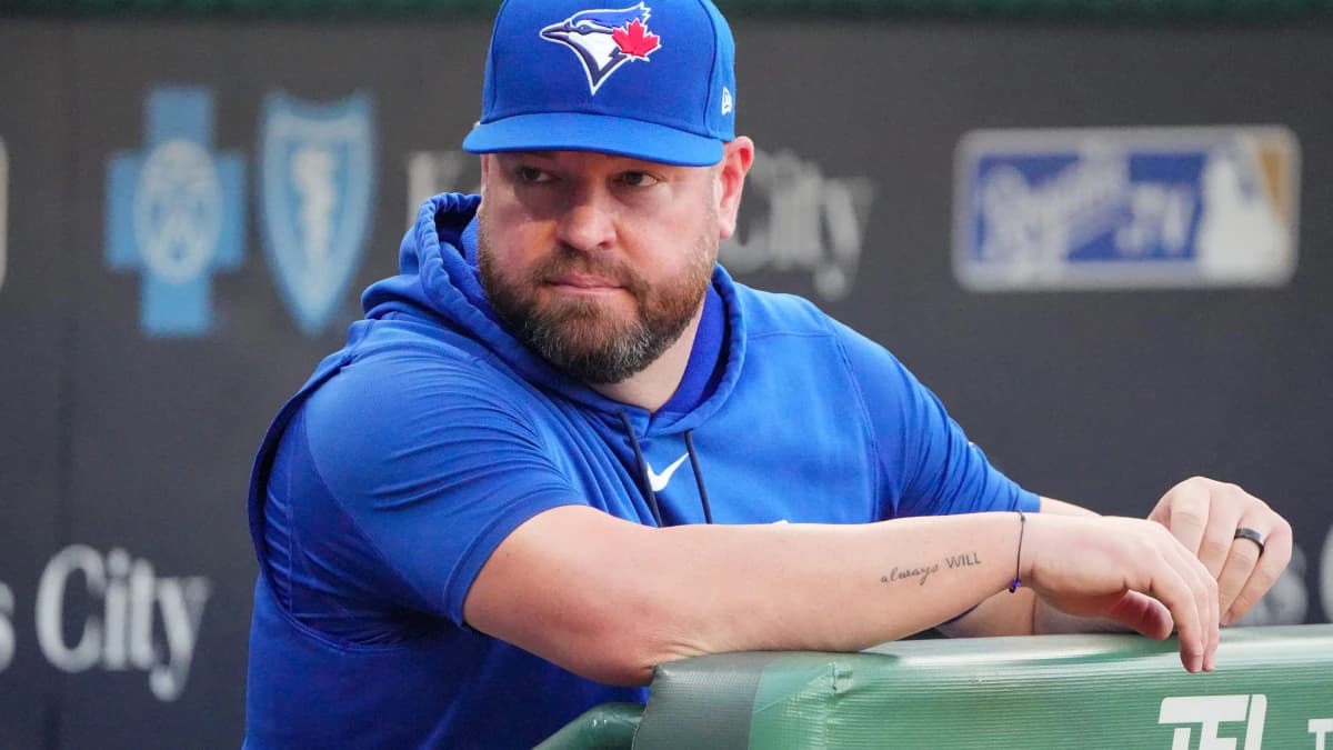 Toronto Blue Jays manager John Schneider (14) looks out from the dugout against the Kansas City Royals prior to a game at Kauffman Stadium.