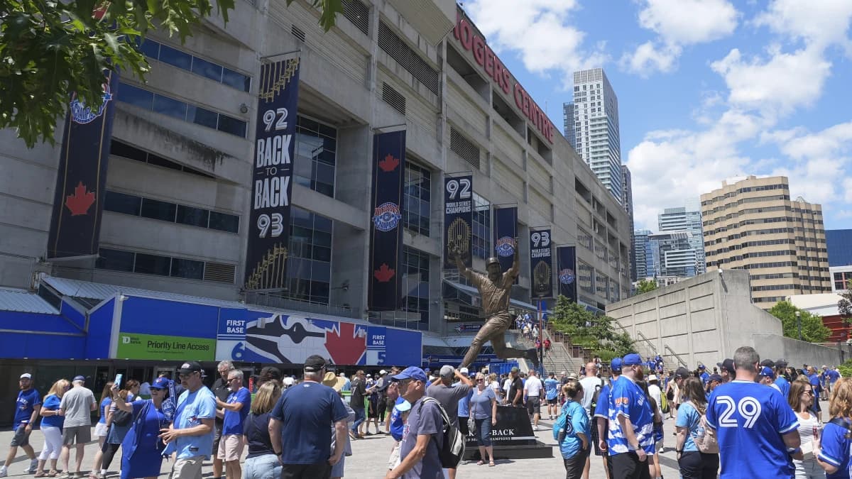 Fans gather around a statue of Joe Carter to commemorate the Toronto Blue Jays back to back World Series wins out side of Rogers Centre before a game between the Tampa Bay Rays and Toronto Blue Jays.