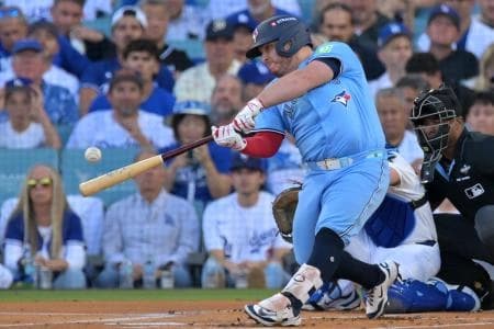Toronto Blue Jays catcher Alejandro Kirk (30) hits a single against the Los Angeles Dodgers in the first inning during game five of the 2025 MLB World Series at Dodger Stadium.