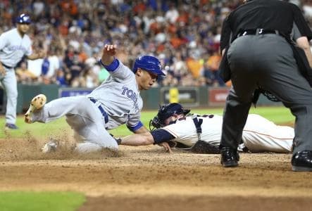 Toronto Blue Jays second baseman Rob Refsnyder (39) reaches home to score a run as Houston Astros catcher Brian McCann (16) applies the tag during the tenth inning at Minute Maid Park.