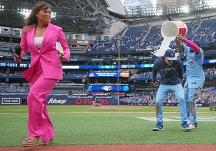 Sportsnet sportscaster Hazel Mae avoids the water bucket by Toronto Blue Jays first baseman Vladimir Guerrero Jr. (27) on shortstop Ernie Clement (28) against the Washington Nationals at the end of the ninth inning at Rogers Centre.