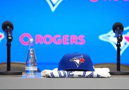 A Toronto Blue Jays cap and jersey sit on the table before the Toronto Blue Jays press conference at Rogers Centre.