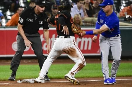 Toronto Blue Jays third baseman Jake Lamb (2) applies the tag on Baltimore Orioles second baseman Jahmai Jones (37) as third base umpire Shane Livensparger (43) looks on at Oriole Park at Camden Yards.