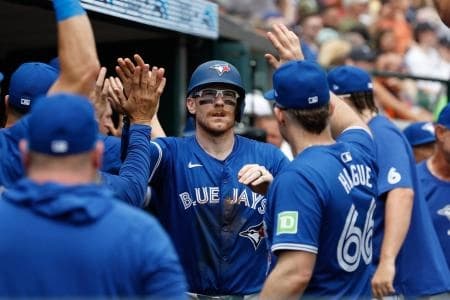 Toronto Blue Jays catcher Danny Jansen (9) celebrates with teammates after scoring a run in the eighth inning of the game against the Detroit Tigers at Comerica Park.