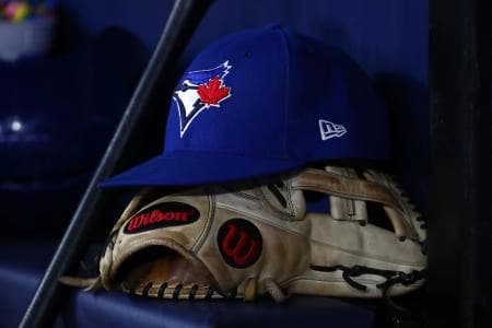 A detail view of a Tampa Bay Rays hat and glove lay in the dugout at Tropicana Field.