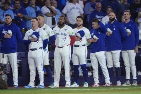 Toronto Blue Jays players line up during the national anthems before game seven of the 2025 MLB World Series against the Los Angeles Dodgers at Rogers Centre.