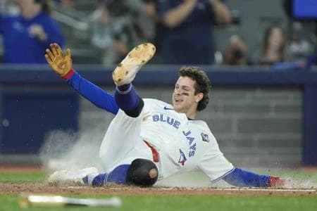 Toronto Blue Jays third baseman Ernie Clement (22) slides to score on a double by shortstop Andres Gimenez (not pictured) in the sixth inning against the Los Angeles Dodgers during game seven of the 2025 MLB World Series at Rogers Centre.