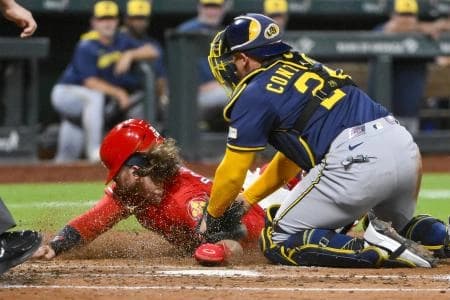 St. Louis Cardinals second baseman Brendan Donovan (33) is tagged out at home by Milwaukee Brewers catcher William Contreras (24) during the third inning at Busch Stadium.