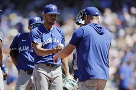Toronto Blue Jays starting pitcher Jose Berrios (17) hands the ball to Toronto Blue Jays manager John Schneider (14) as he leaves during the seventh inning against the Seattle Mariners at T-Mobile Park.