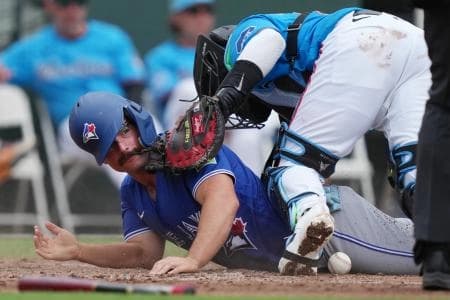 Toronto Blue Jays second baseman Davis Schneider (36) scores a run as Miami Marlins catcher Brian Navarreto (64) drops the ball at the plate in the third inning at Roger Dean Chevrolet Stadium.