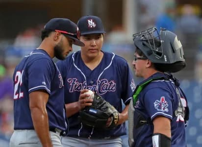 New Hampshire Fisher Cats starting pitcher Fernando Perez, center, has a meeting at the mound with shortstop Alex De Jesus, left, and catcher Robert Brooks during the second inning of a Minor League Baseball game at Canal Park, Aug. 21, 2025, in Akron, Ohio.
