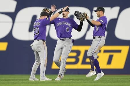 Colorado Rockies left fielder Troy Johnston (20) and center fielder Brenton Doyle (9) and right fielder Tyler Freeman (2) celebrate a win over the Toronto Blue Jays after the tenth inning at Rogers Centre.