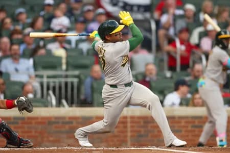 Athletics third baseman Andy Ibanez (77) hits an RBI single against the Atlanta Braves in the second inning at Truist Park.