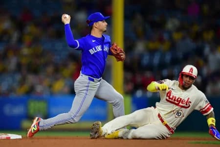 Los Angeles Angels third baseman Yoan Moncada (10) is out at second as Toronto Blue Jays shortstop Andres Gimenez (0) throws to first for the out against first baseman Nolan Schanuel (18) during the ninth inning at Angel Stadium.