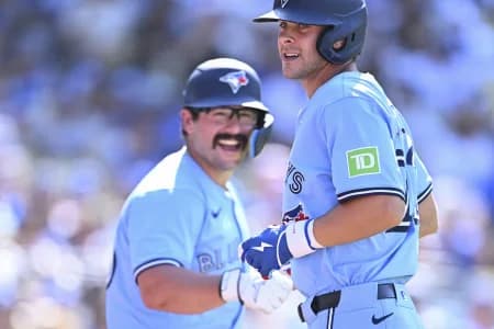 Toronto Blue Jays second baseman Ernie Clement (22) celebrates with outfielder Davis Schneider (36) after hitting a solo home run against the Los Angeles Dodgers during the ninth inning at Dodger Stadium. M