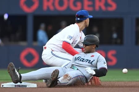 Miami Marlins second baseman Xavier Edwards (9) slides safely into second base after hitting a double as Toronto Blue Jays second baseman Andres Gimenez (0) takes the throw from the outfield in the first inning at Rogers Centre.