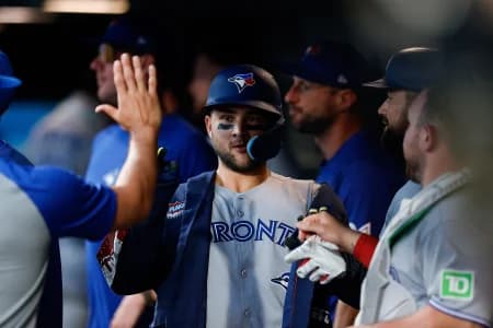 Toronto Blue Jays designated hitter Bo Bichette (11) celebrates in the dugout on a two run home run in the third inning against the Colorado Rockies at Coors Field.
